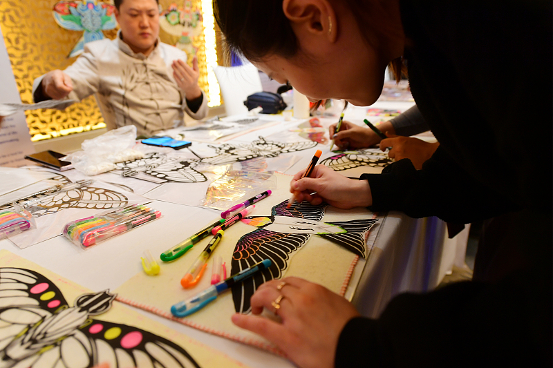 Visitors create a bird-shaped kite at a cultural event in Beijing, November 27, 2023. /CFP