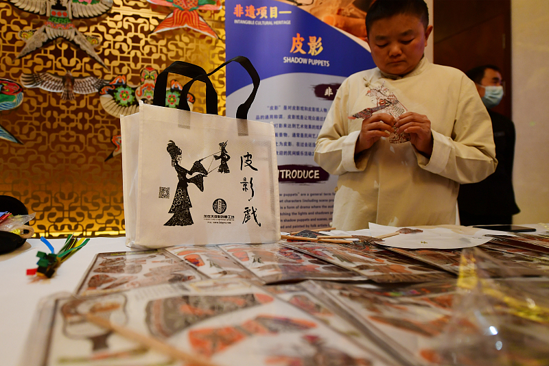 An artisan creates shadow puppets at a cultural event in Beijing, November 27, 2023. /CFP