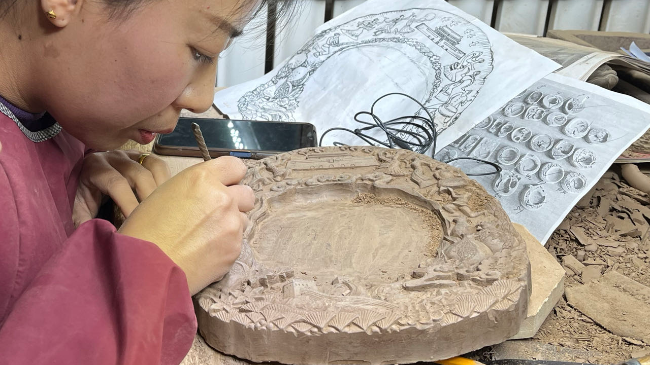 A photo taken on November 15, 2023 shows a woman carving a Chengni inkstone in Xinjiang County of Yuncheng, north China's Shanxi Province. /CGTN