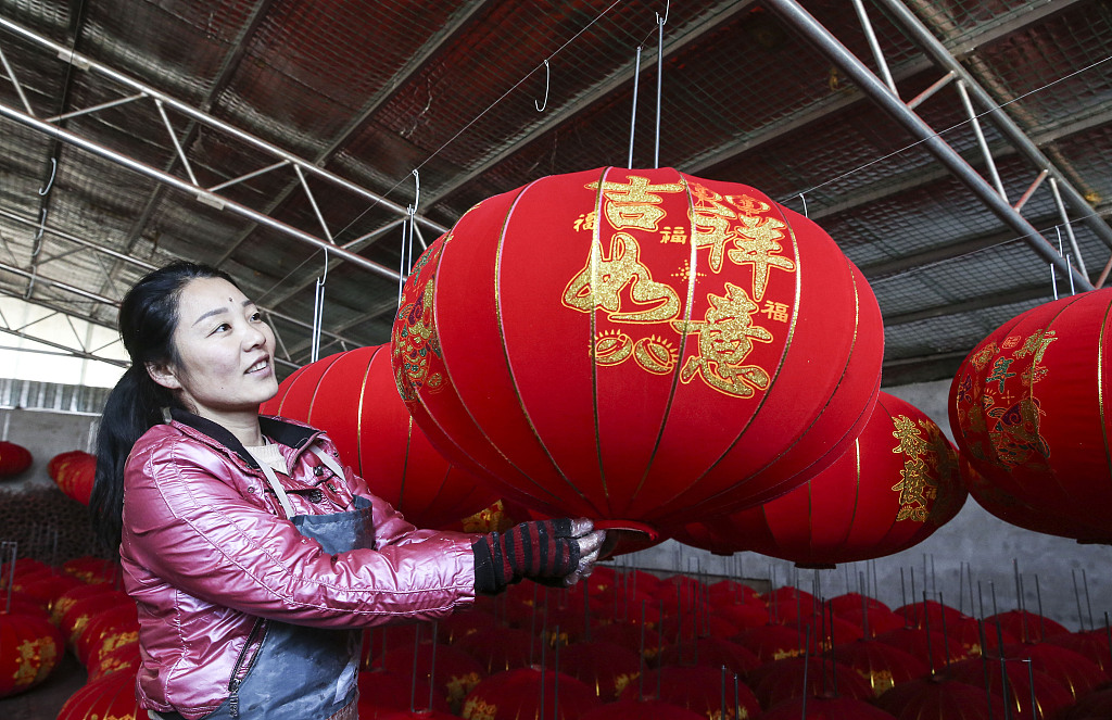 A worker in Yangzhao Village, Yuncheng City, Shanxi Province, holds a red lantern on December 1, 2023. /CFP