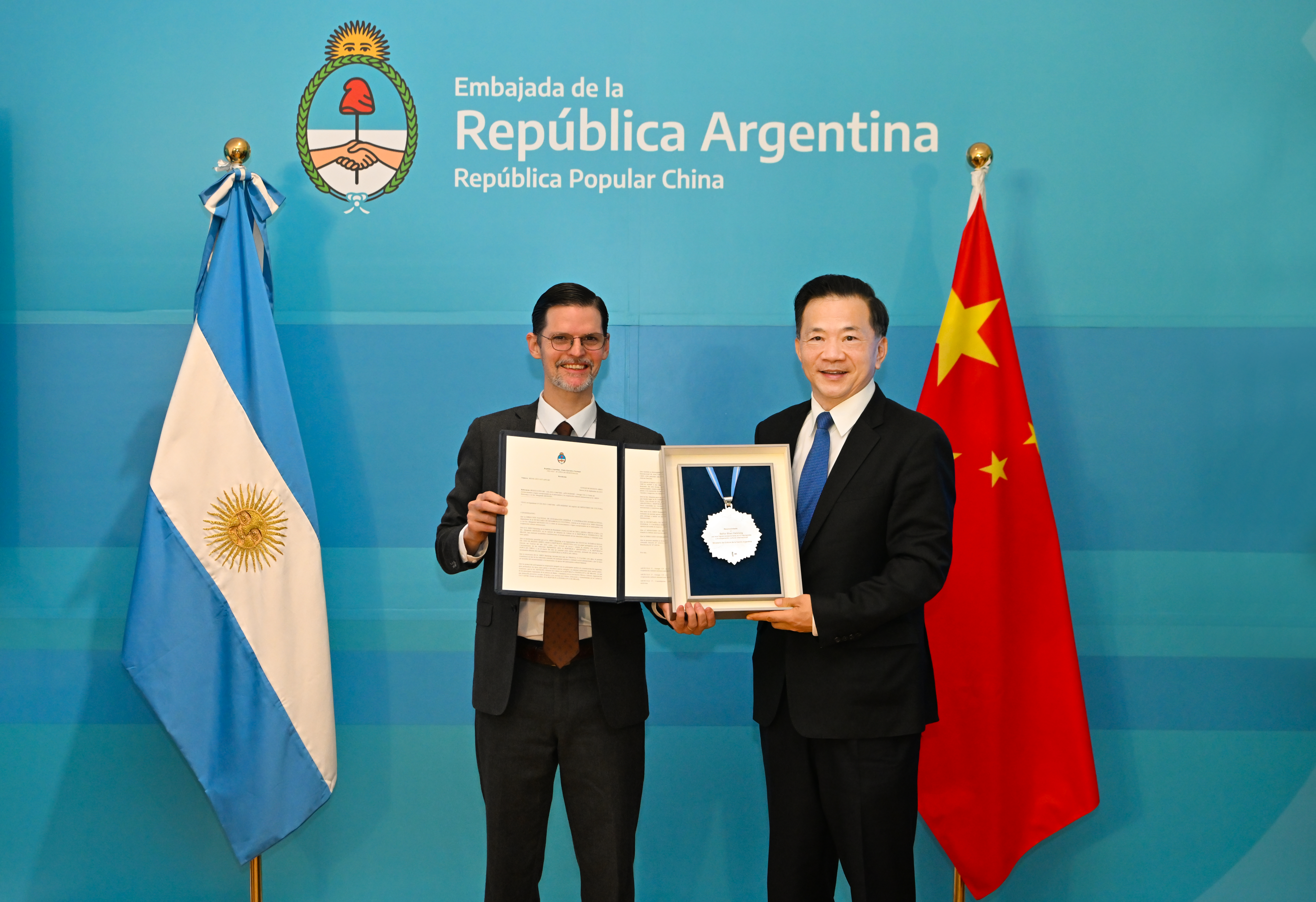 Shen Haixiong (R), vice minister of the Publicity Department of the Communist Party of China Central Committee and president of China Media Group, is granted the Outstanding Achievement Award for International Cultural Exchanges and Cooperation by Argentine Ambassador to China Sabino Vaca Narvaja in Beijing, China, December 1, 2023. /Argentine Embassy in China