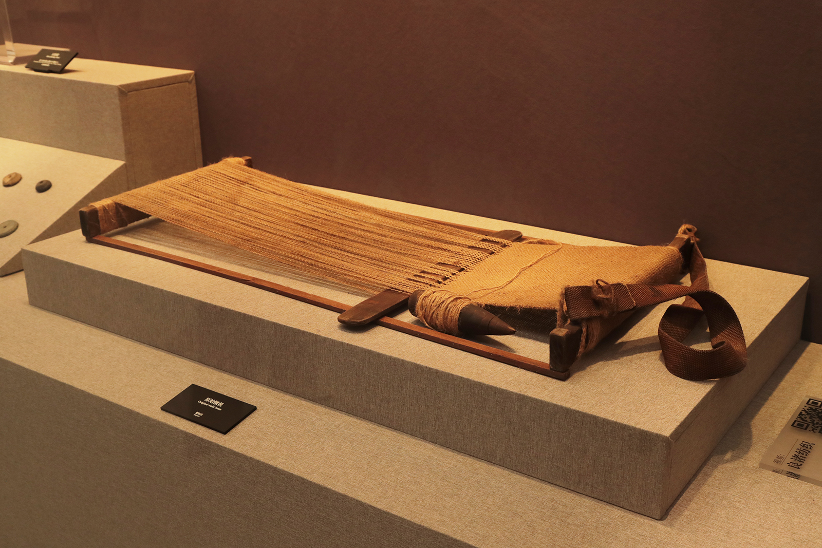 A replica of an original waist loom used during the time of Liangzhu Ancient City is on display at the Liangzhu Museum in Hangzhou, Zhejiang Province. /CGTN