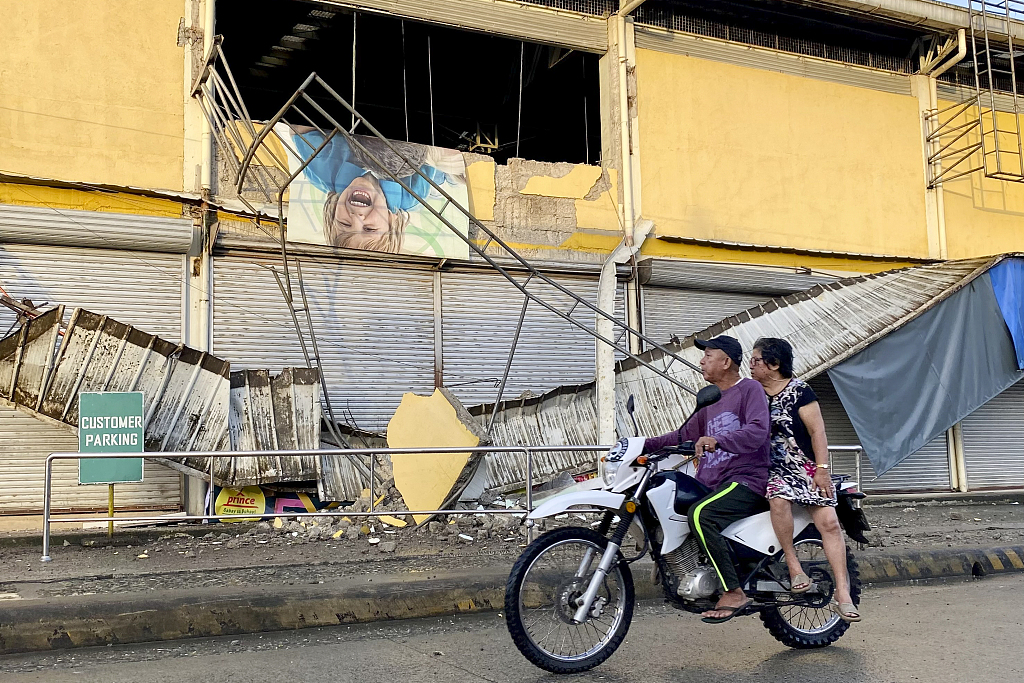 A motorcycle passes a grocery store damaged by an earthquake in Bayugan City, Agusan del Sur, southern Philippines, December 3, 2023. /CFP