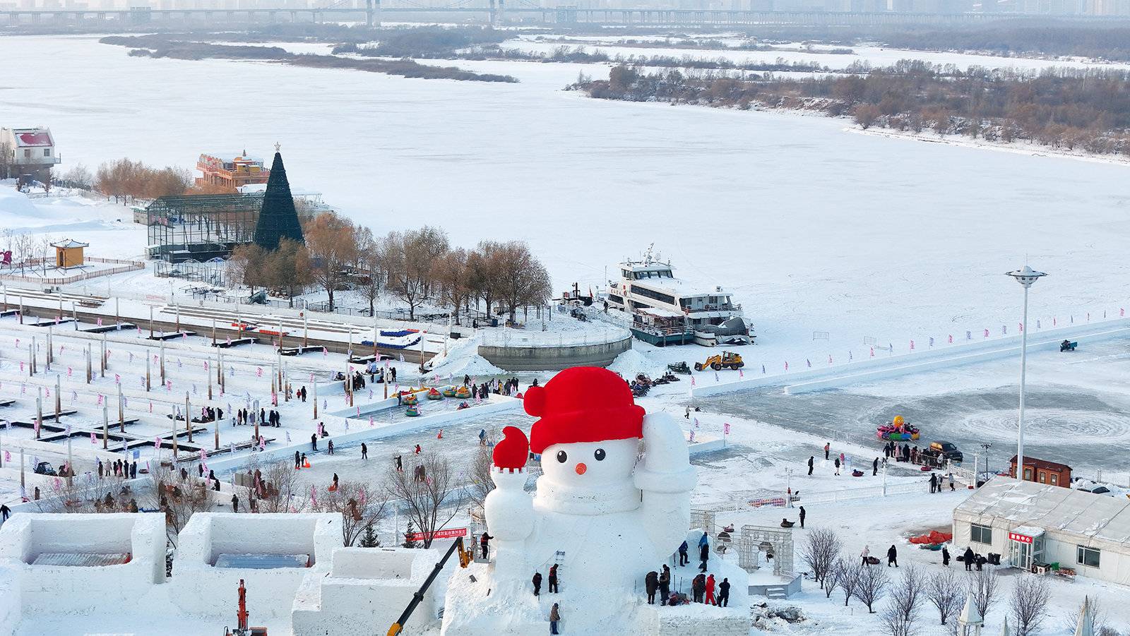 Workers add the finishing touches to a giant snowman being built on the banks of the Songhua River in Harbin, Heilongjiang Province, on December 3, 2023. /IC