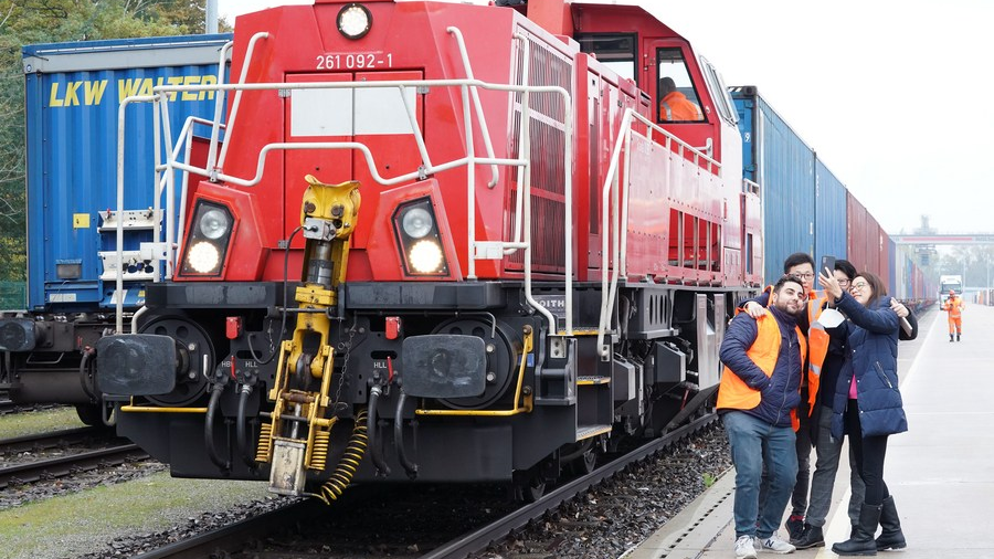 Staff members pose for photos with the first Shanghai Express, a China-Europe freight train linking Shanghai with Europe, in Hamburg, Germany, October 26, 2021. /Xinhua