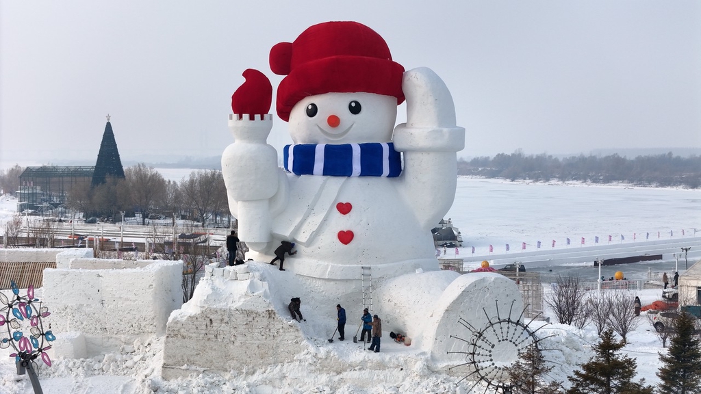 A photo shows workers putting the final touches to a 20-meter-high snowman in Harbin, northeast China's Heilongjiang Province, on December 5, 2023. /IC