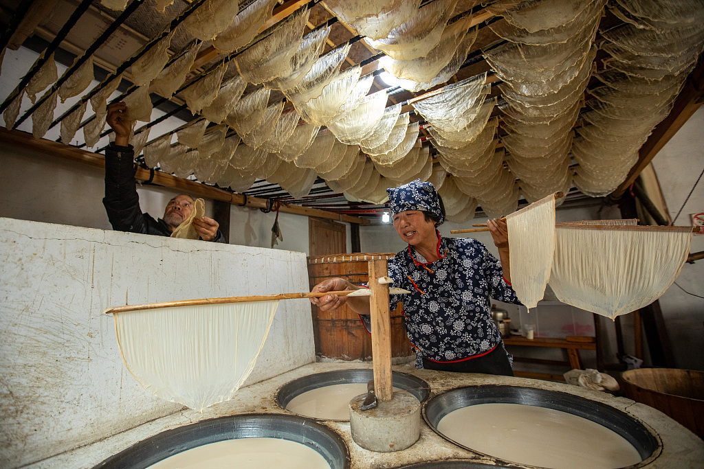 A photo taken on December 5, 2023 shows a woman making tofu skin at home, in Jinhua, Zhejiang Province, China. /CFP