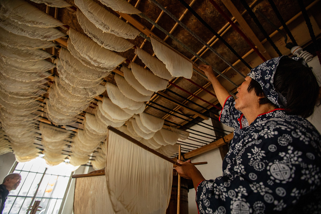 A photo taken on December 5, 2023 shows a woman making tofu skin at home, in Jinhua, Zhejiang Province, China. /CFP