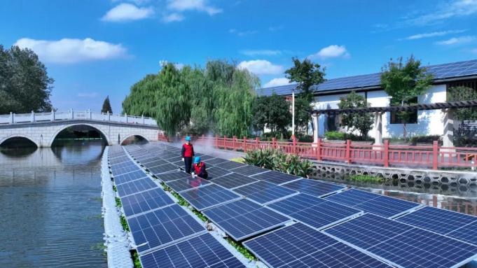 The State Grid Haining Power Supply Company provided Changxiao Village with an agricultural photovoltaic integration solution which involved installing photovoltaic panels on the top of mushroom greenhouses. /He Jijiang