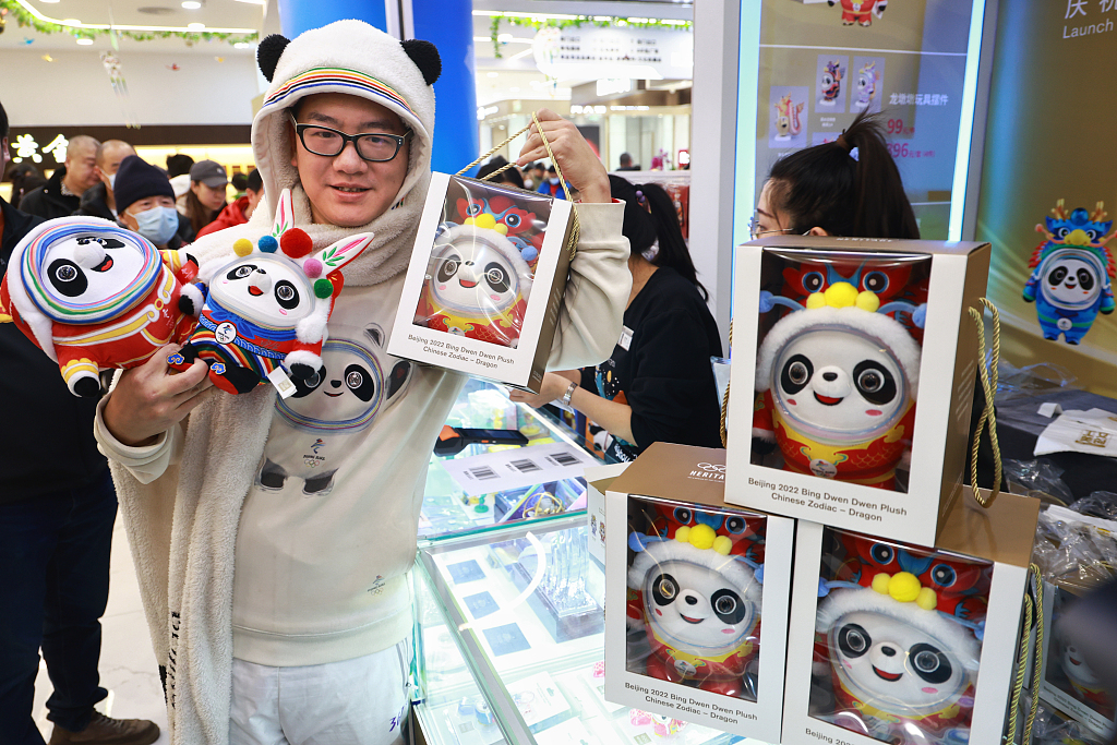 A customer shows purchased products of dragon-costumed Bing Dwen Dwen in Beijing, on December 7, 2023. /CFP