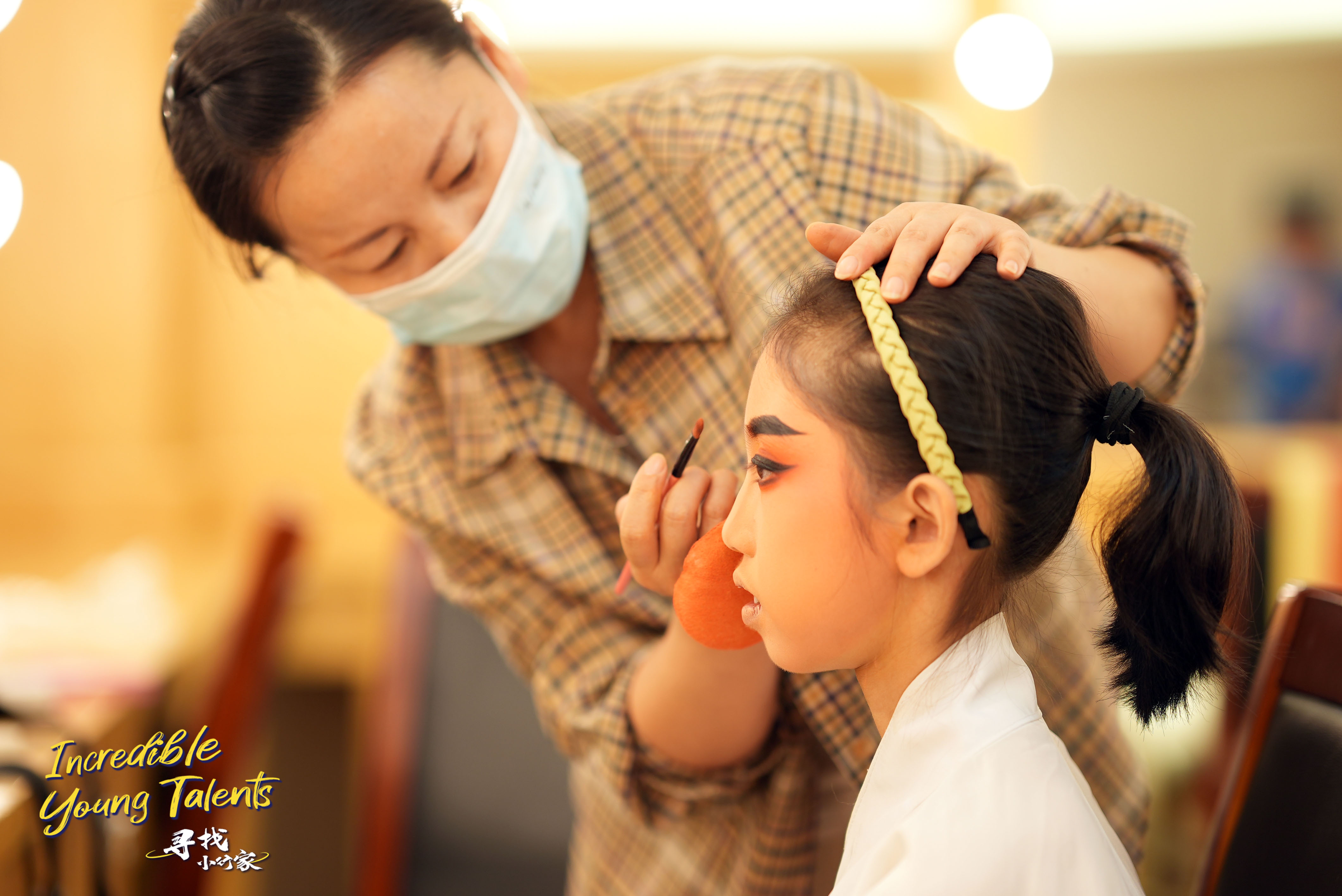 A teacher helps Wang Yuhan apply makeup for a male role in Yueju Opera. /CGTN