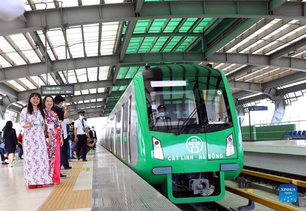 People take photos next to the China-built Cat Linh-Ha Dong metro line, which is the first metro line in Vietnam to start commercial operation, in Hanoi, Vietnam, November 6, 2021. /CFP