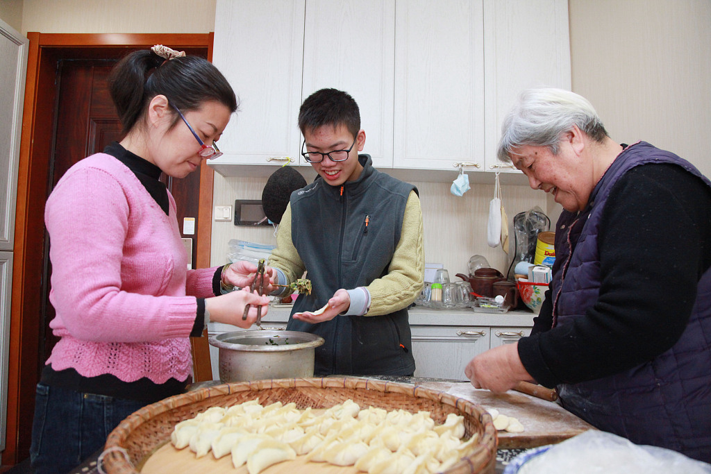 A family in Nanjing, Jiangsu Province, China makes dumplings at home on January 21, 2023, on Chinese New Year's Eve. /CFP