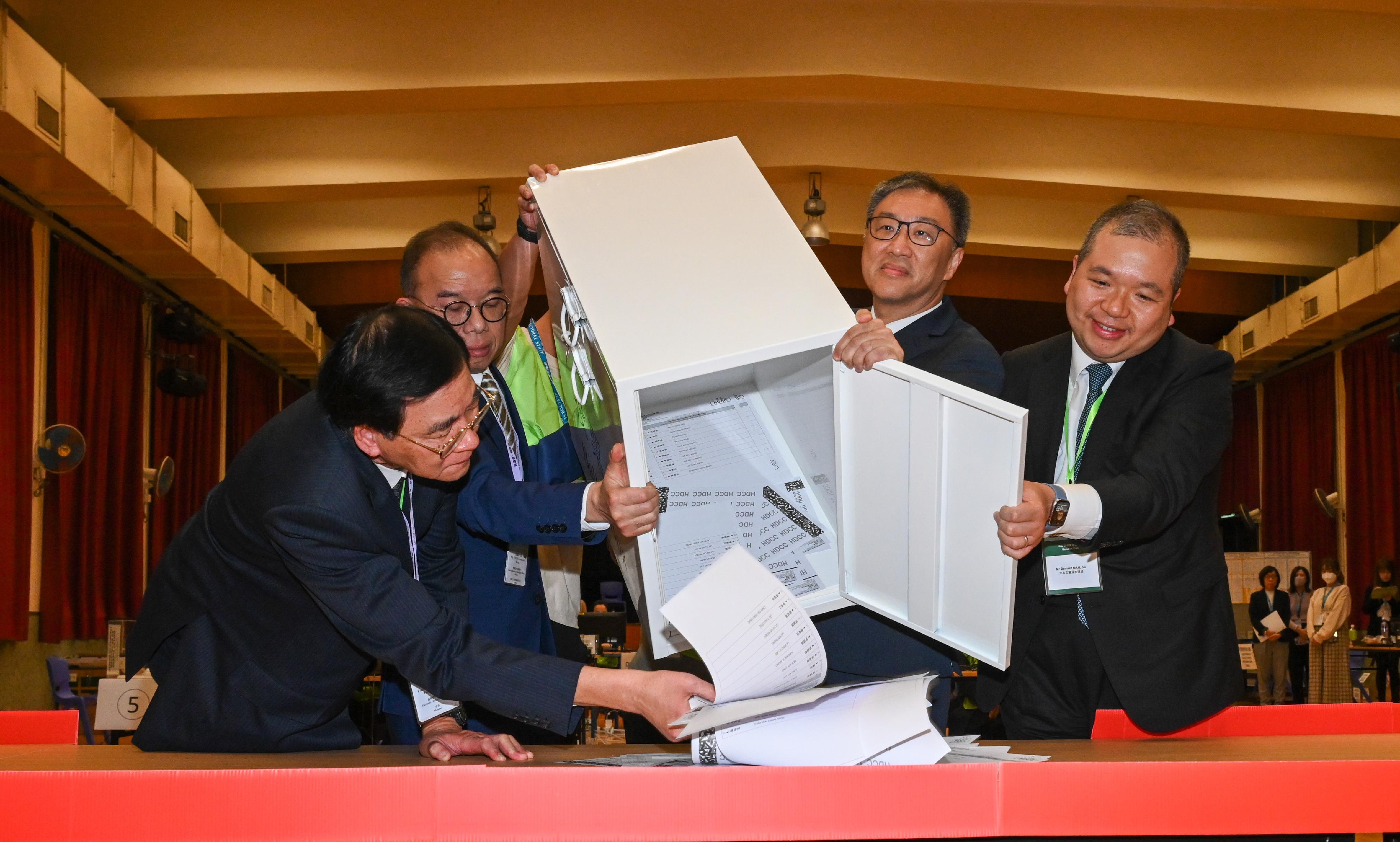 Officials of the HKSAR government and staff empty a ballot box at a counting station of the 2023 DC Ordinary Election at Ng Wah Catholic Secondary School in south China's Hong Kong, December 10, 2023. /HKSAR Government