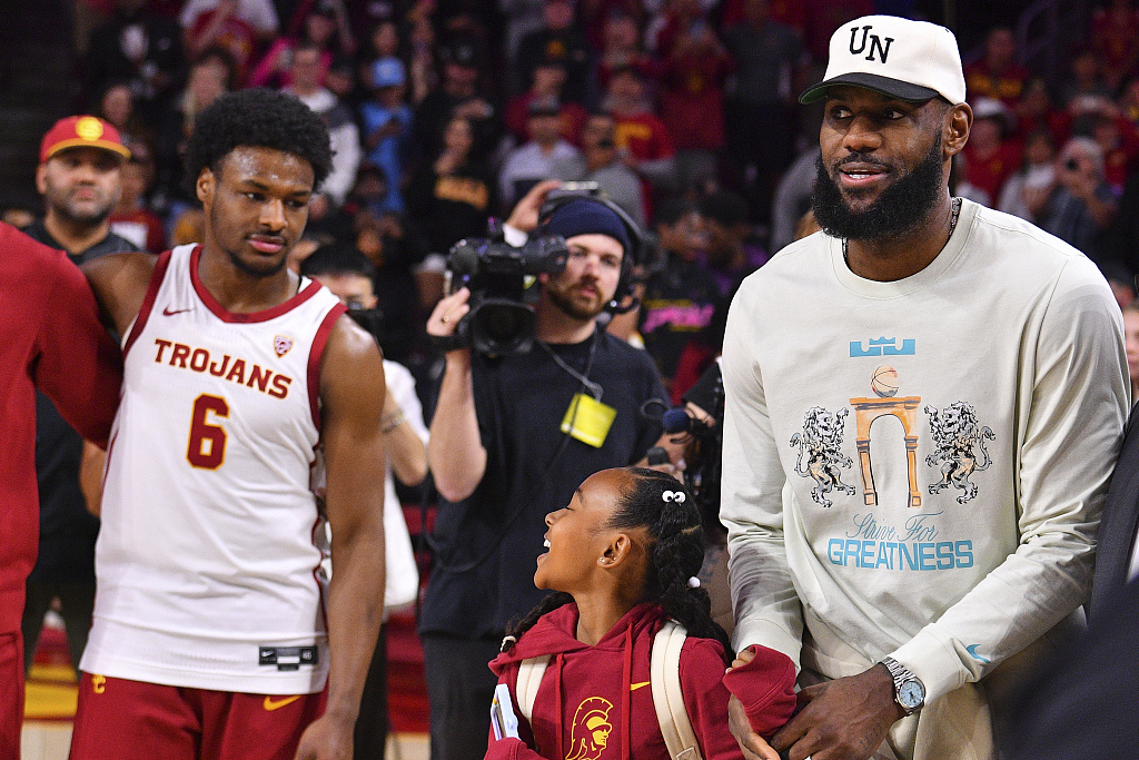 Los Angeles Lakers forward Lebron James (R) and his daughter Zhuri Nova (C) walk past USC Trojans guard Bronny James (#6) before the college basketball game in Los Angeles, U.S., December 10, 2023. /CFP