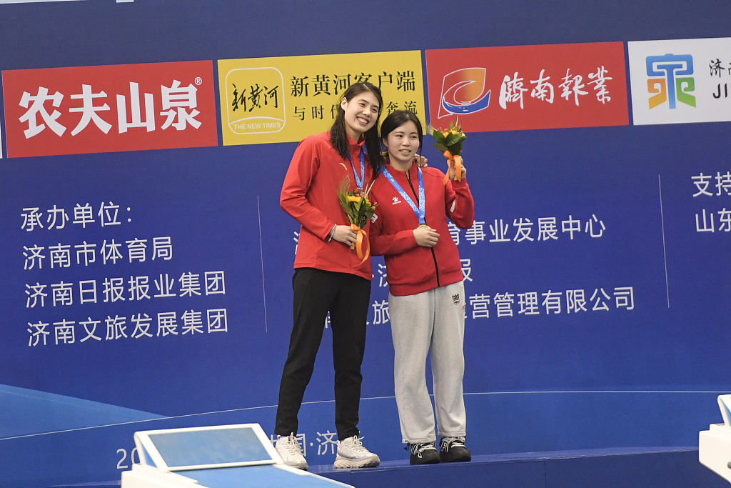 China's Zhang Yufei (L) celebrates with her coach after winning the women's 100m butterfly final during the Chinese National Swimming Championships in Jinan, China, December 10, 2023. /CFP