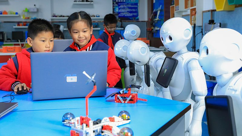 Students conduct tests on the humanoid robots in a primary school in Huzhou, Zhejiang Province, November 29, 2023. /CFP