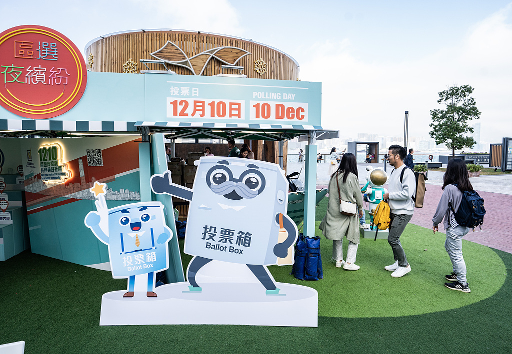People visit a promotional booth, which call on citizens to vote in the District Council elections, in the Hong Kong Special Administrative Region, China, December 9, 2023. /CFP