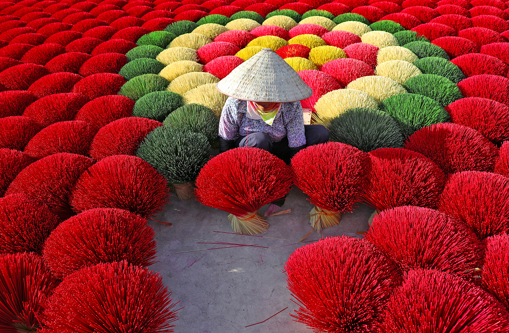 A photo taken on October 5, 2023 shows a worker bundling and arranging incense sticks in the sun in Quang Phu Cau, Vietnam. /CFP