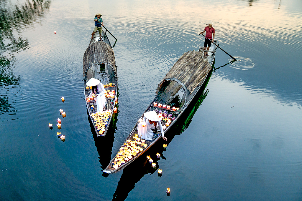 Vietnamese women float flower lanterns on river for good fortune - CGTN