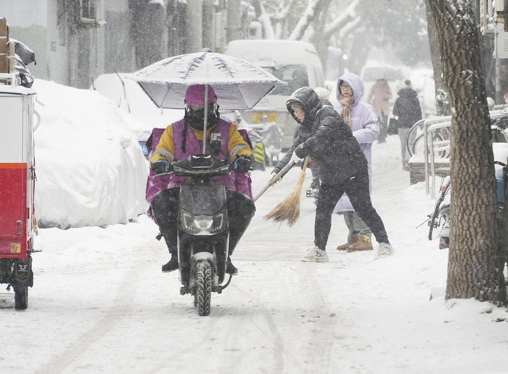 Riding a motorcycle amid heavy snowfall in Beijing, China, December 14, 2023. /CFP 