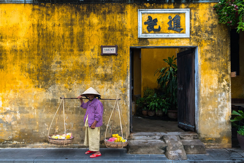 A file photo shows a woman selling goods outside a house in Hoi An, Vietnam. /CFP