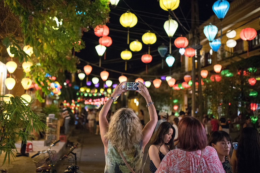 A file photo shows a tourist taking photos of lanterns in Hoi An, Vietnam. /CFP