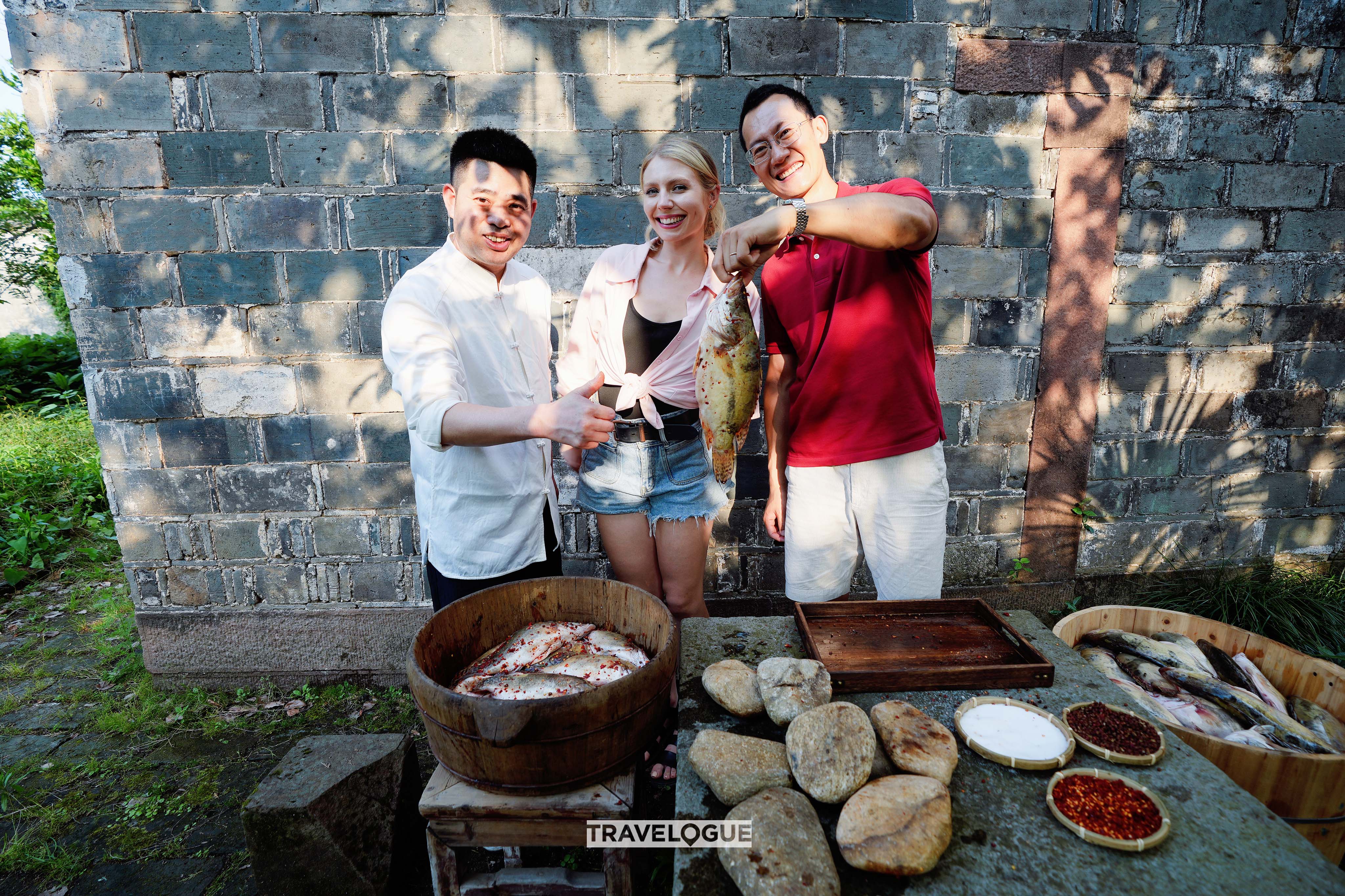 CGTN's Travelogue hosts help prepare a dish of Stinky Mandarin Fish. /CGTN