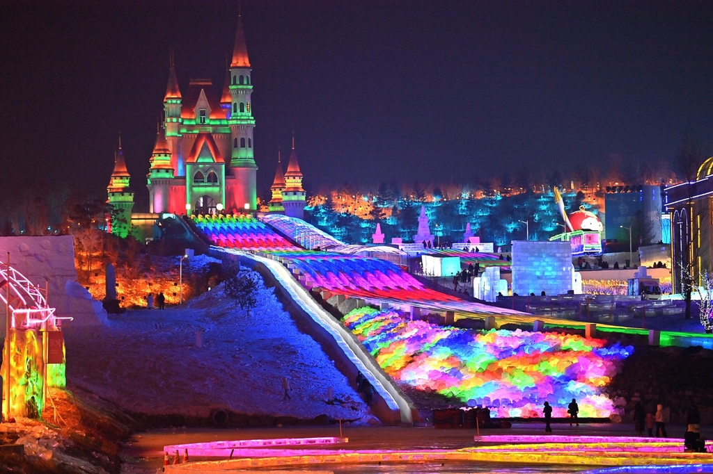 A photo shows a multi-lane, ultra-long ice slide lit up in rainbow colors at this year's Changchun Ice and Snow New World in Changchun, Jilin Province on December 12, 2023. /IC