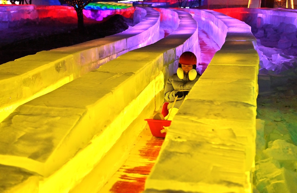 A photo shows a visitor enjoying the ultra-long ice slide at this year's Changchun Ice and Snow New World in Changchun, Jilin Province on December 12, 2023. /IC