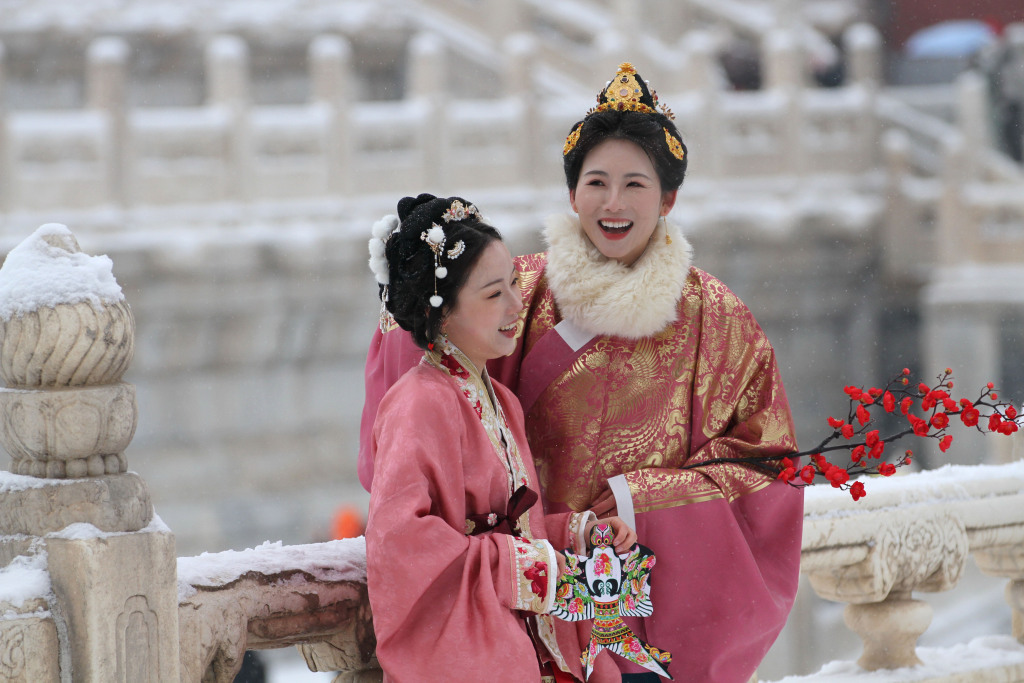 A photo shows two women dressed in traditional attire visiting the Forbidden City in Beijing, on December 13, 2023. /CFP