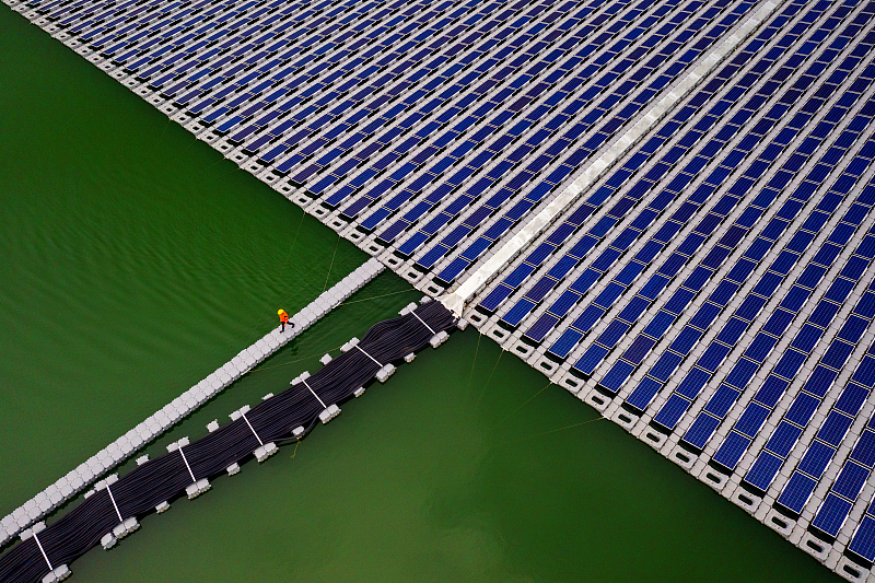 A worker walks across a floating solar panel farm at the Da Mi power plant, a solar project implemented by PowerChina, on the lake of the same name in the Binh Thuan province, Vietnam, September 29, 2021. /CFP