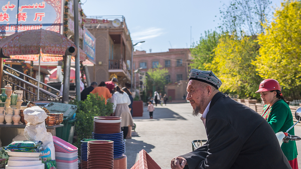 A resident asks about the price of goods in Kashgar, northwest China's Xinjiang Uygur Autonomous Region, April 12, 2019. /VCG 