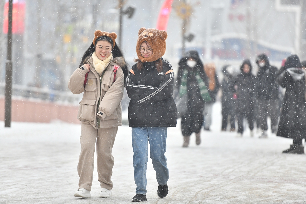 Two visitors to the Universal Beijing Resort were spotted in the snow wearing a themed hat and hair band respectively on December 14, 2023. /CFP