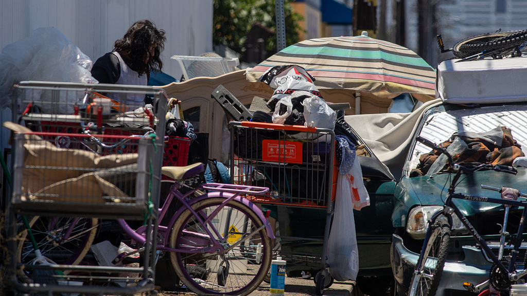 A homeless man sorts through belongings at a sidewalk encampment on Deering Avenue in Canoga Park, California, U.S., July 10, 2023. /CFP