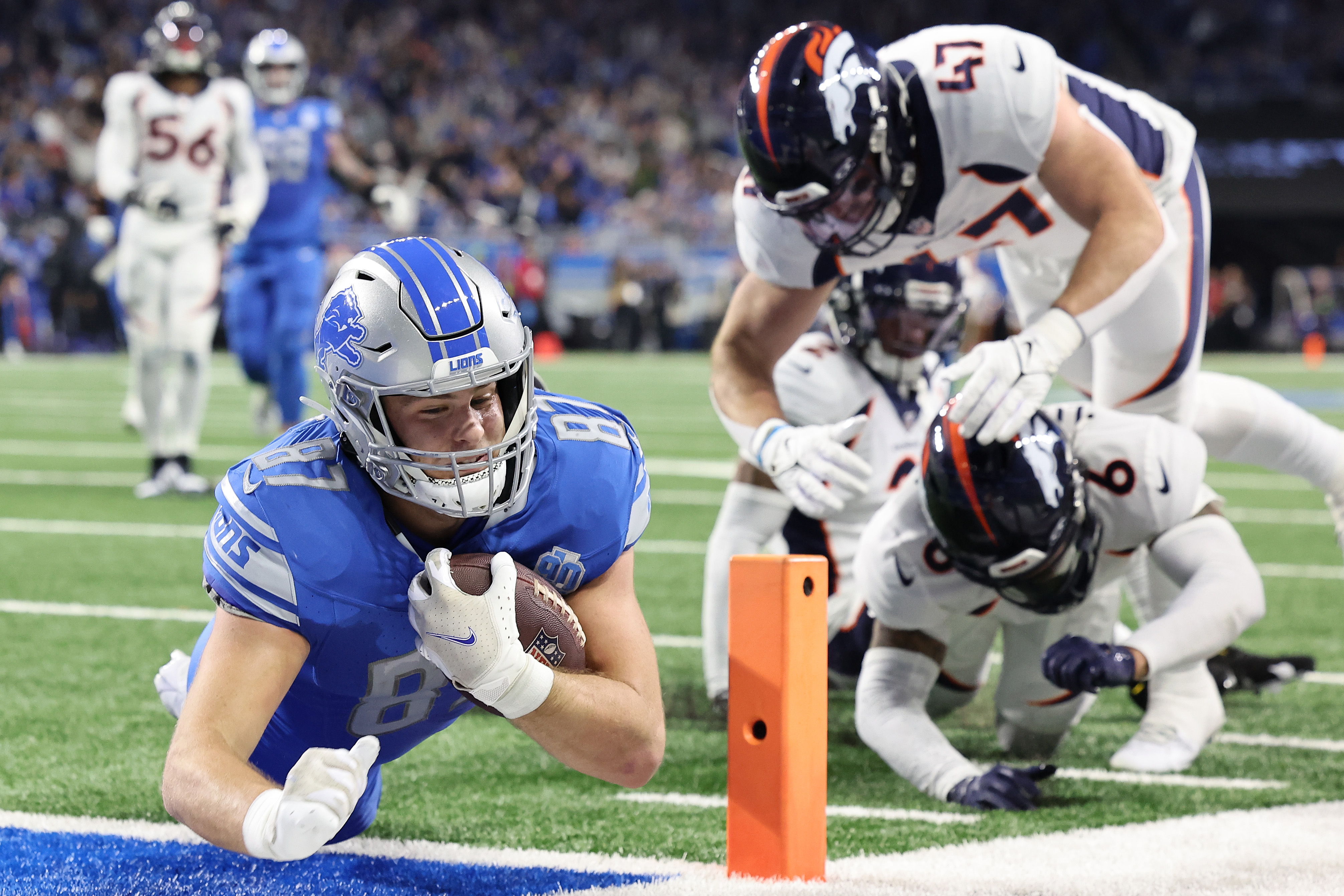 Tight end Sam LaPorta (L) of the Detroit Lions dives into the end zone to score a touchdown in the game against the Denver Broncos at Ford Field in Detroit, Michigan, December 16, 2023. /CFP