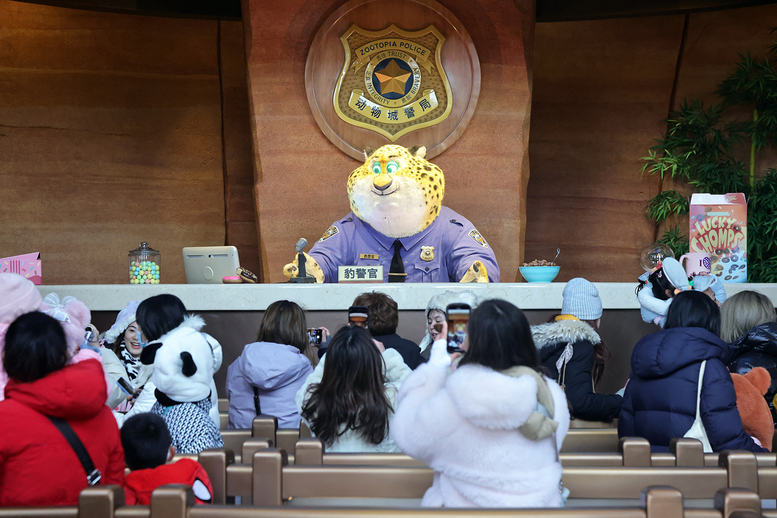 Visitors interact with Benjamin Clawhauser, an obese cheetah officer in the animated film 