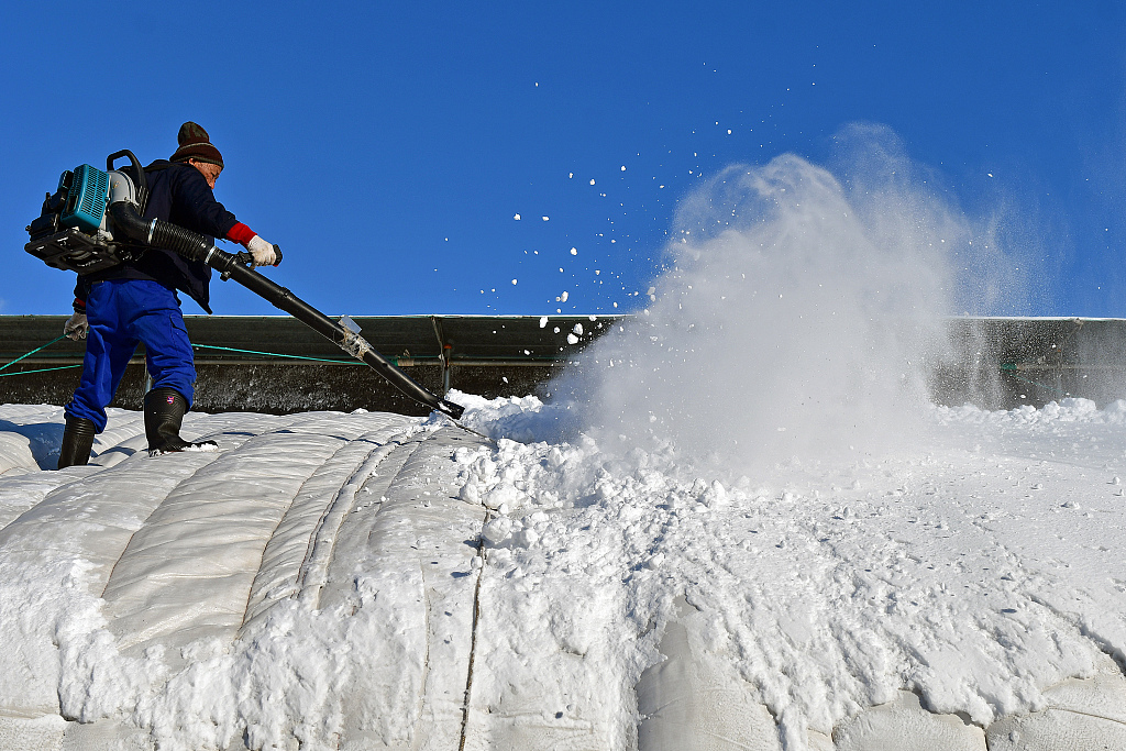 Farmer uses a blower to clear the snow on the roof, Shandong Province, China, December 17, 2023. /CFP