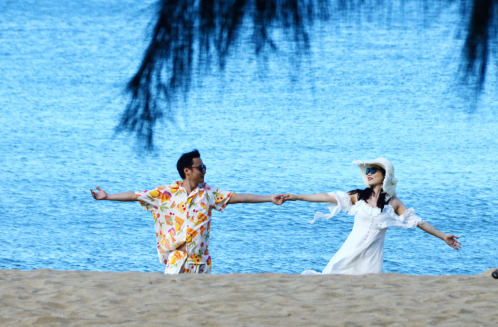 Photo taken on November 15, 2023 shows a couple enjoying the warm weather on a beach in Sanya, Hainan. /CFP