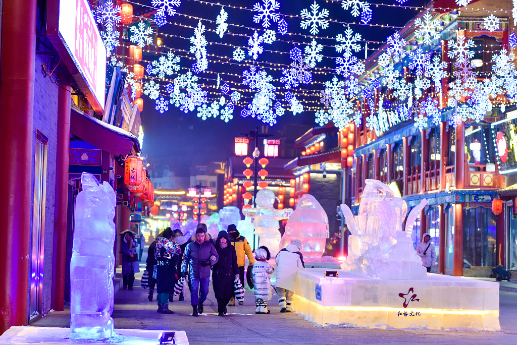 Lit-up snowflake decorations hang above ice sculptures in the Hailar District of Hulunbuir, Inner Mongolia on December 18, 2023. /CFP