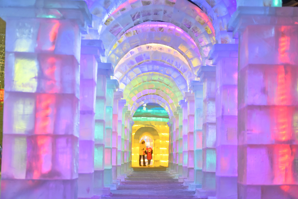 Visitors walk under ice sculpture arches in the Hailar District of Hulunbuir, Inner Mongolia on December 18, 2023. /CFP