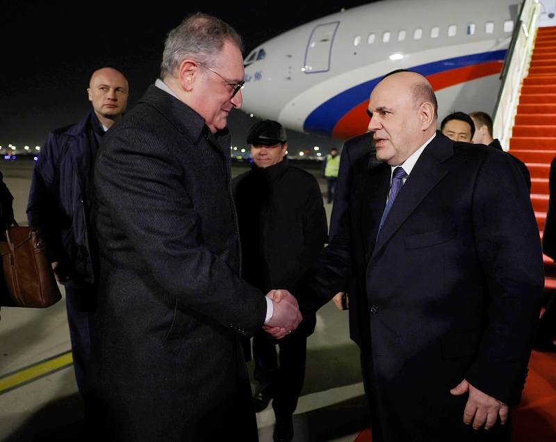 Russian Prime Minister Mikhail Mishustin is greeted by Russian Ambassador to China Igor Morgulov, left, upon arrival at Beijing Capital International Airport, December 18, 2023. /CFP