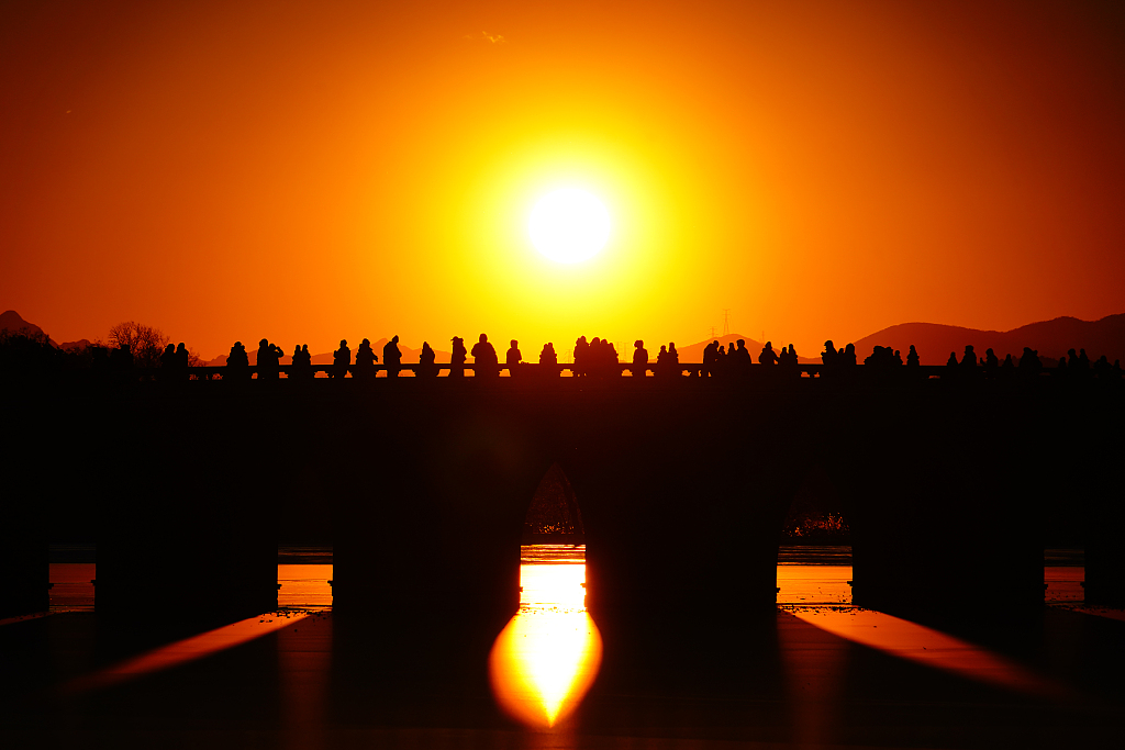 A photo taken on December 19, 2023 shows golden sunlight piercing through the arches of the Seventeen-Arch Bridge at the Summer Palace in Beijing. /CFP