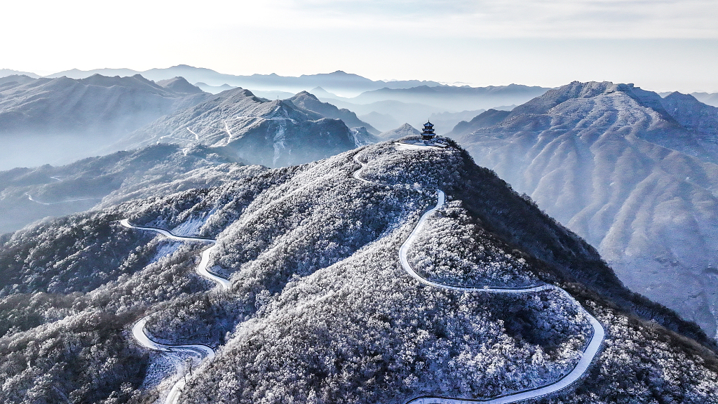 A bird's-eye view photo taken on December 19, 2023 shows the winding mountain roads in the snow-covered Longtou Mountain Scenic Area in Hanzhong, Shaanxi Province. /CFP