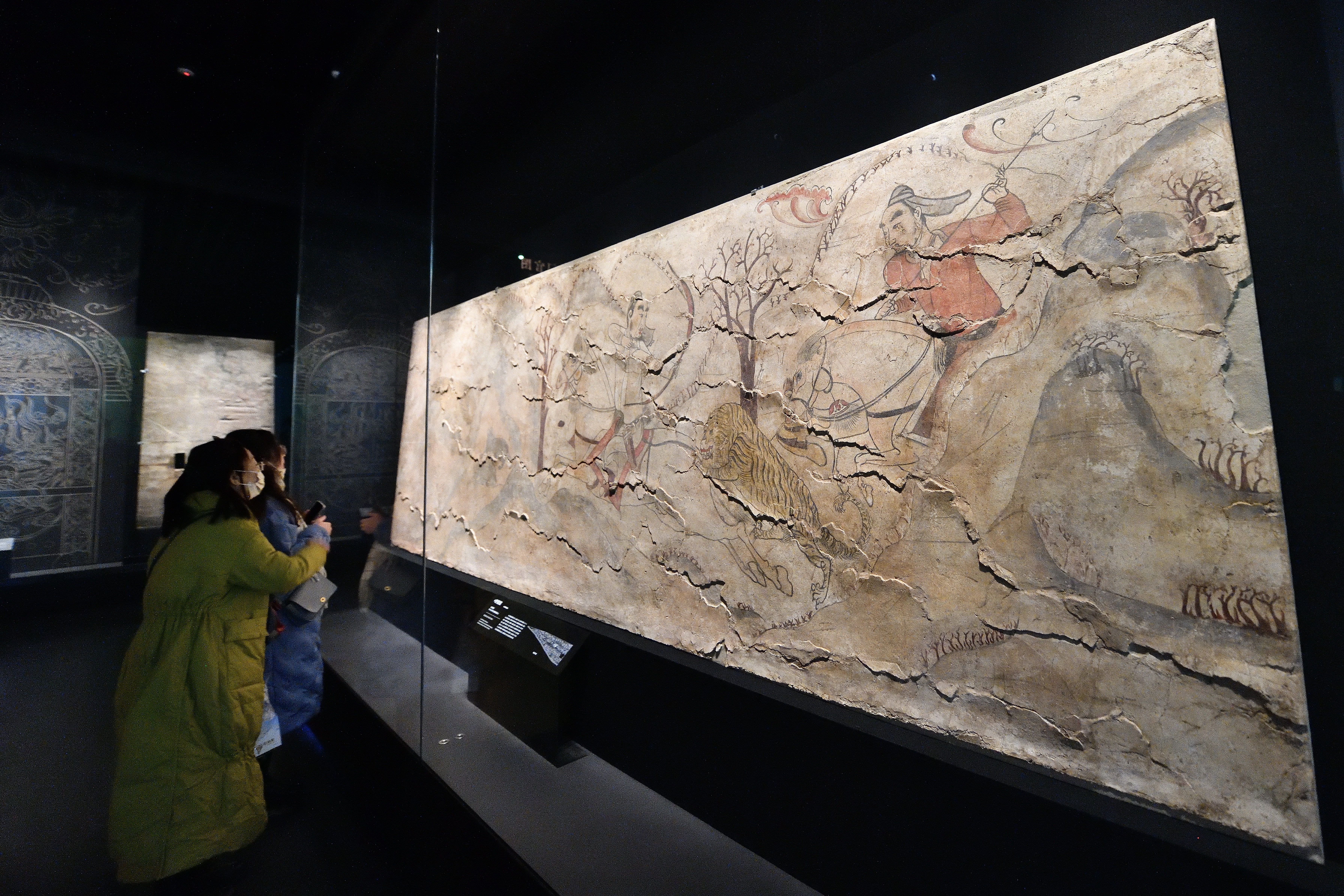 Visitors appreciate ancient murals on display at the Taiyuan Northern Qi Dynasty Mural Museum in Shanxi Province, December 20, 2023. /IC