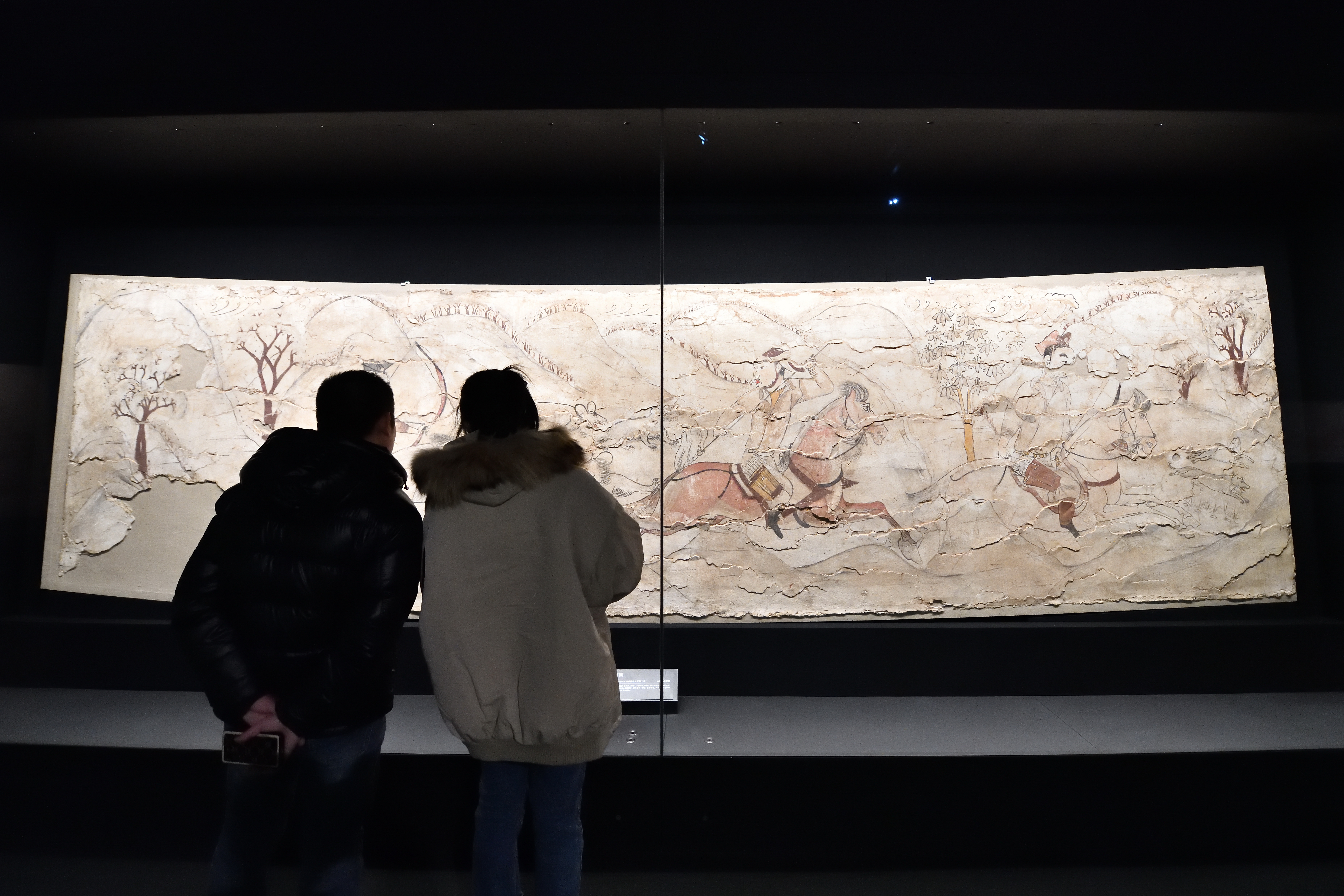 Visitors appreciate ancient murals on display at the Taiyuan Northern Qi Dynasty Mural Museum in Shanxi Province, December 20, 2023. /IC