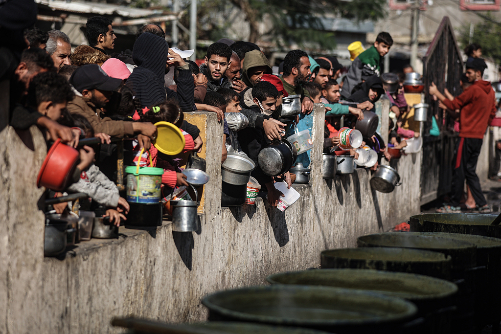 Crowds of displaced residents wait for a meal of lentil soup in Rafah, south of the Gaza Strip, December 18, 2023. /CFP