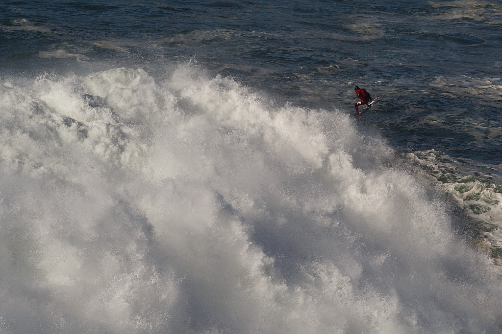 A surfer rides a big wave at Teahupo'o in Tahiti, French Polynesia, August 17, 2023. /CFP