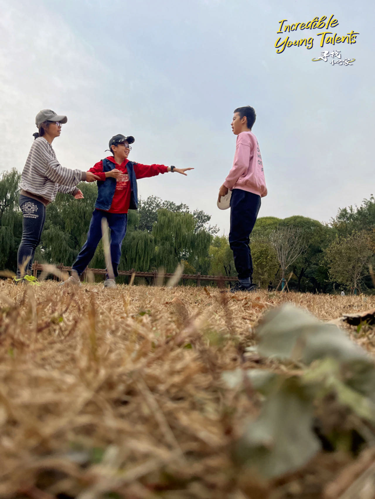 Zhu Jingxiu plays frisbee with his mother and older brother at a public park in Beijing. /CGTN
