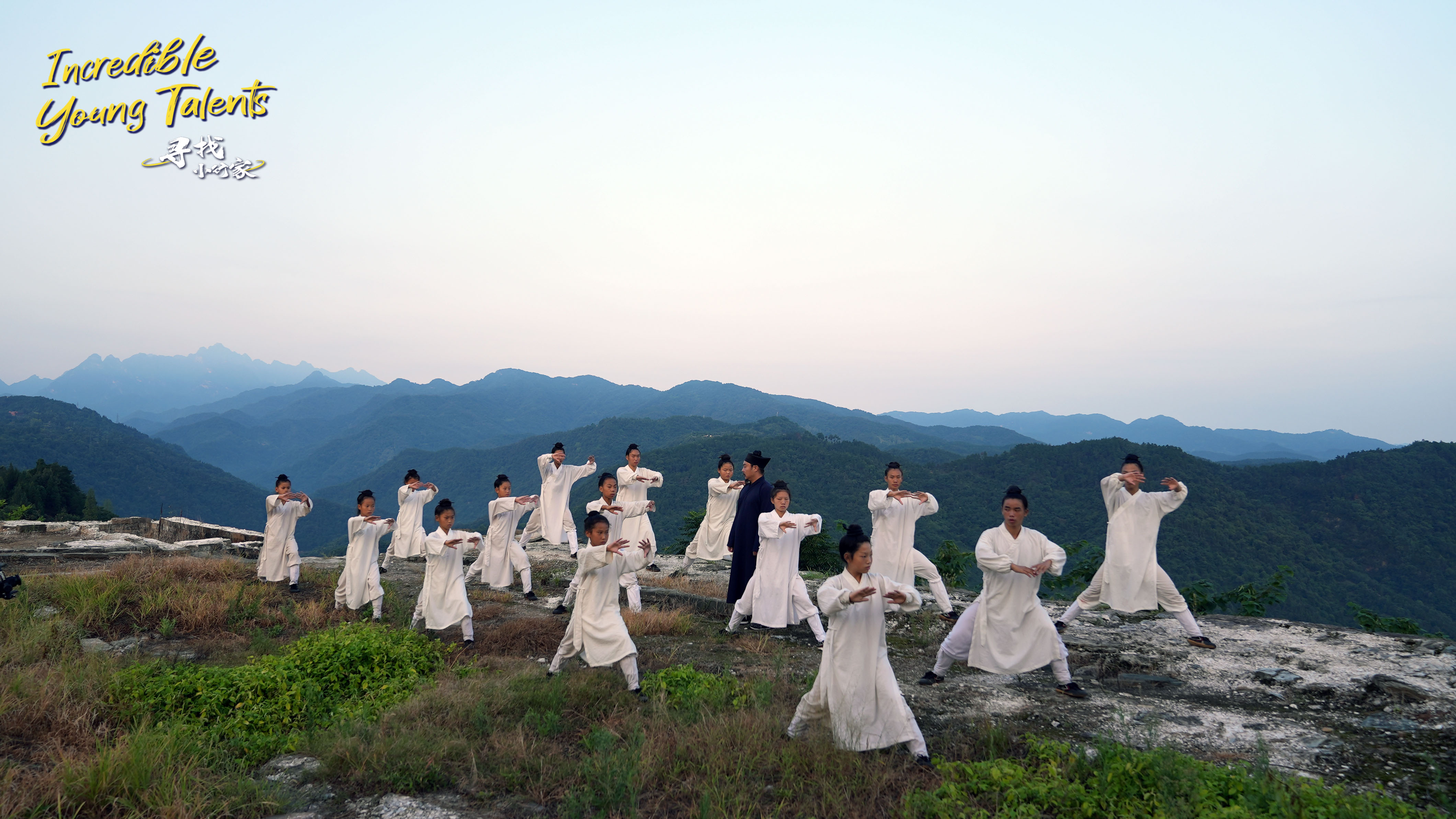 Tai Chi master Hu Weizhe (center) teaches young apprentices basic routines in the Wudang Mountains. /CGTN
